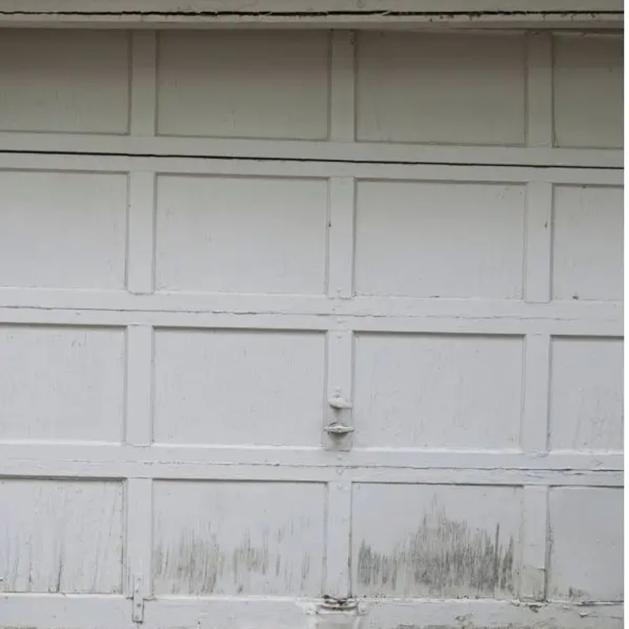 A worn, weathered garage door before replacement